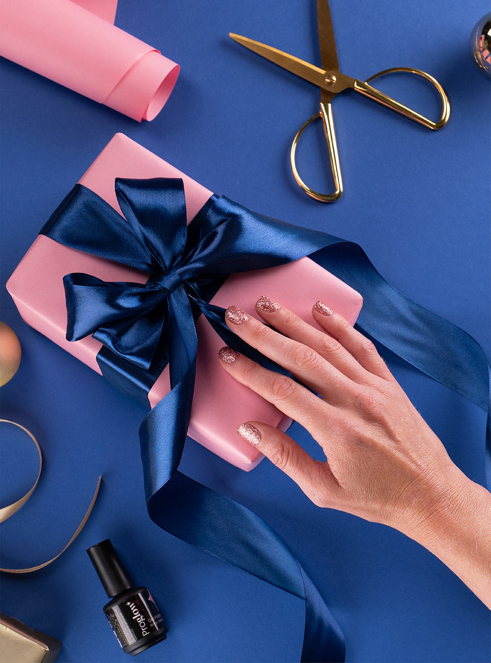 Ongles Noël 2025 avec vernis rose et touches pailletées, nail art semi-permanent festif